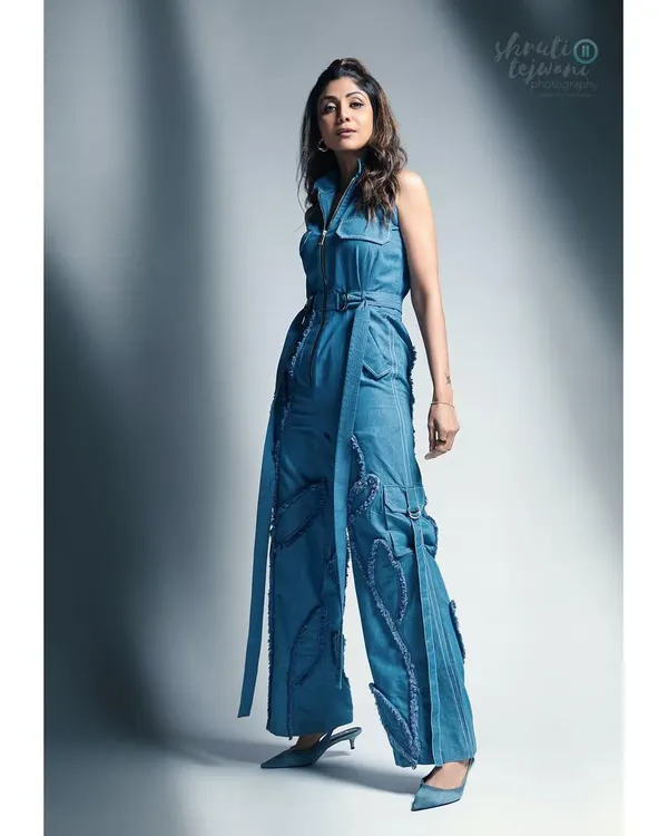 A full-length shot of Shilpa Shetty, showcasing her powerful presence and the stylish denim jumpsuit. This is a great example of a full-body branding portrait.