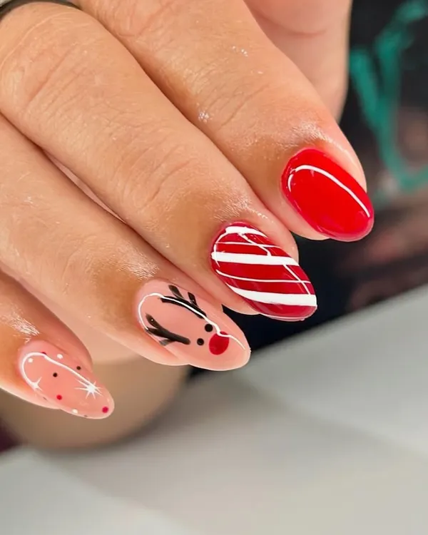 Getting into the holiday spirit with this cute Christmas-themed manicure. We hand-painted a little reindeer, a candy cane stripe, and some festive sparkles.
