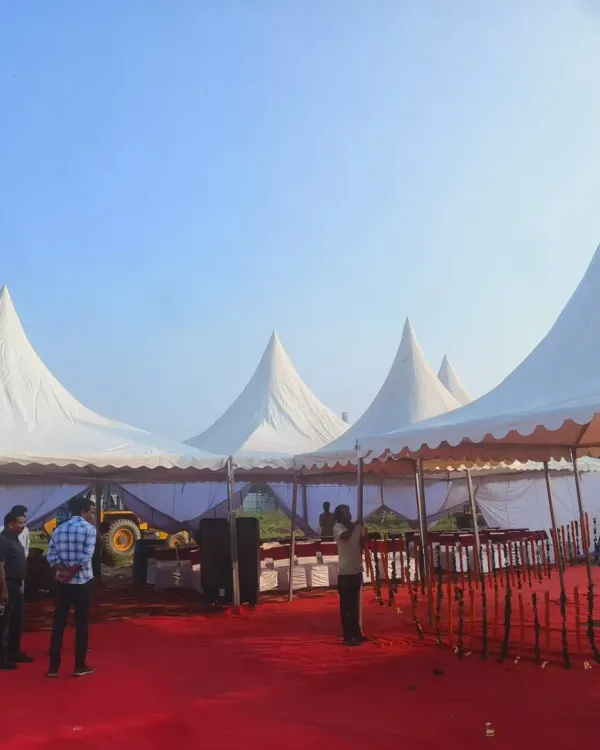 A corporate event setup in progress in Greater Noida, featuring multiple white pagoda tents arranged on a red carpeted area. This structure is ideal for creating separate zones for stalls, registration, or activities.