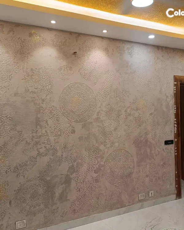 In this living room, we paired a false ceiling with warm downlights with a sophisticated IDC Calcecruda wall texture. The combination of ceiling design and wall finish creates a rich, layered, and modern aesthetic.