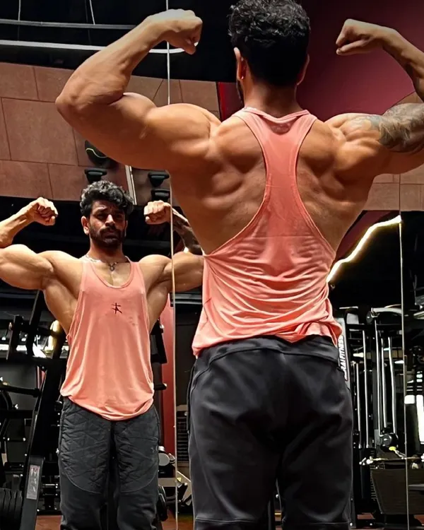 A mirror check showing the results of a dedicated back and shoulder routine. My programs focus on creating that V-taper and impressive rear double biceps pose.