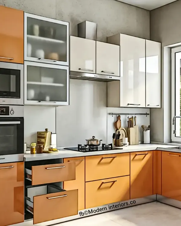 This L-shaped modular kitchen features a warm orange and white color scheme with handle-less cabinets for a sleek look. We incorporated a mix of drawers and cabinets, along with a built-in oven, to ensure maximum functionality and an organized workflow.