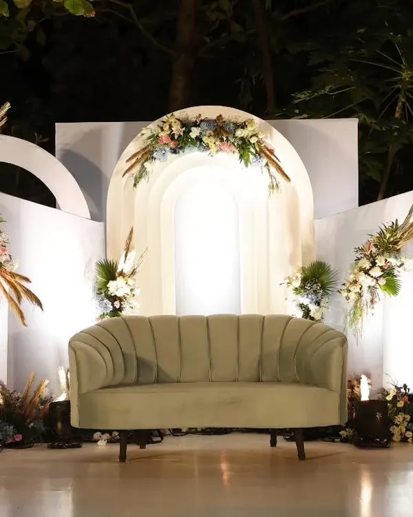 A beautiful stage we designed for Ezekiel's First Holy Communion. The modern white arches are softened with bohemian-style floral arrangements featuring pampas grass, creating a look that is both contemporary and serene.