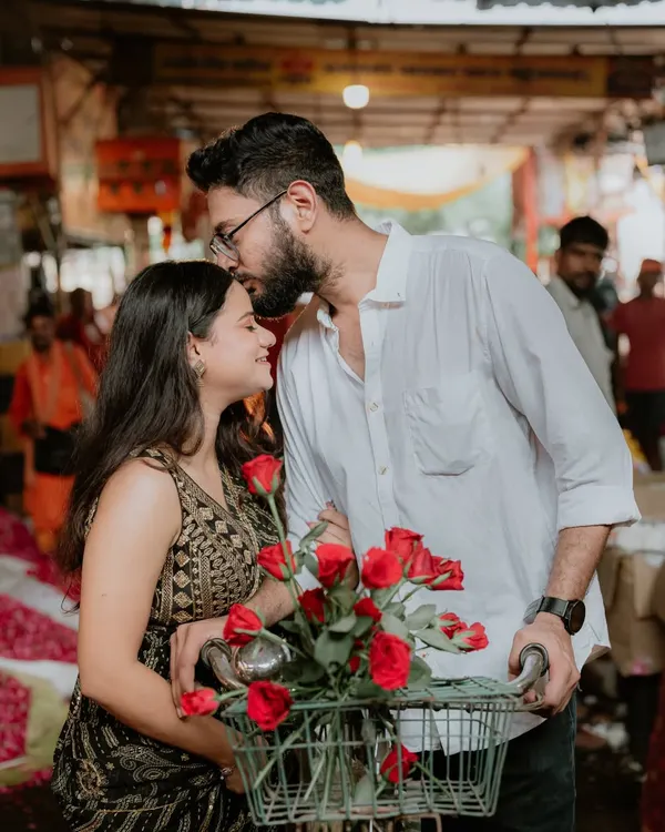 A romantic kiss on the forehead amidst the chaos of the Ghazipur flower market. The roses in the bicycle basket add a classic romantic touch to this unique and candid setting.