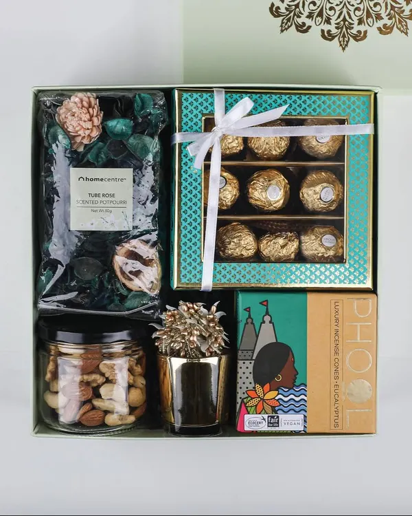 Our 'Royal Blend' hamper is a perfect mix of modern and traditional. It features Ferrero Rocher chocolates, premium mixed nuts, potpourri, and other festive items in an elegant gift box.
