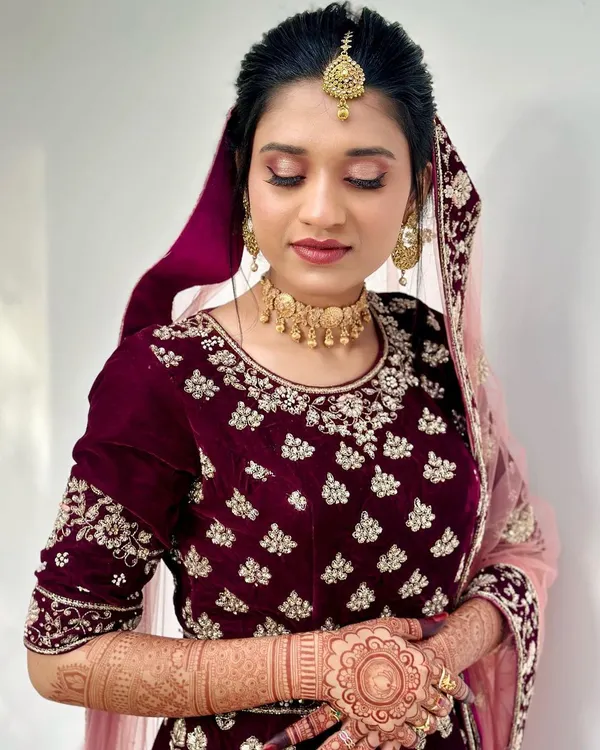 The beautiful bride Shahana, looking serene after her makeup was done. Her rich henna stain complements her stunning maroon and gold wedding attire perfectly.