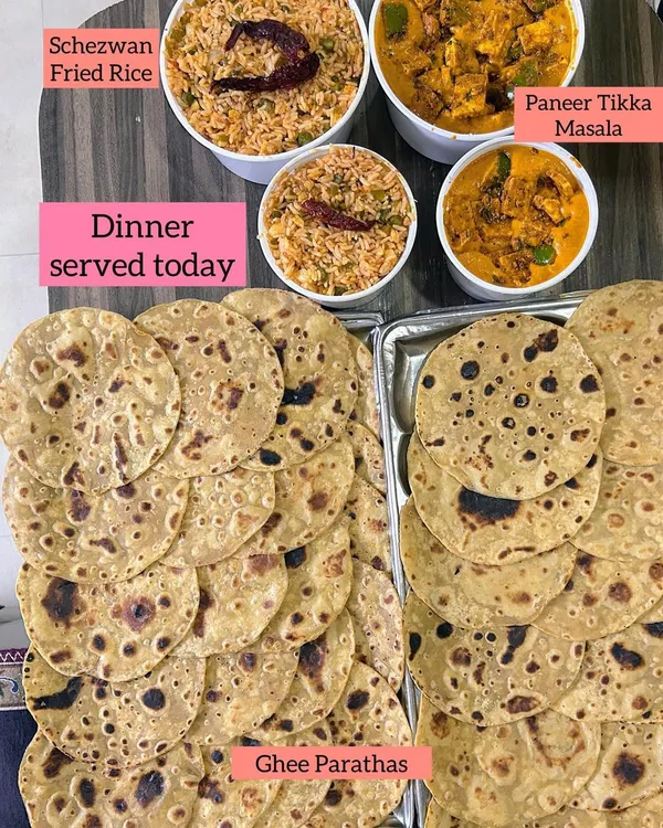 A wholesome dinner of Schezwan Fried Rice, Paneer Tikka Masala, and stacks of soft Ghee Parathas.