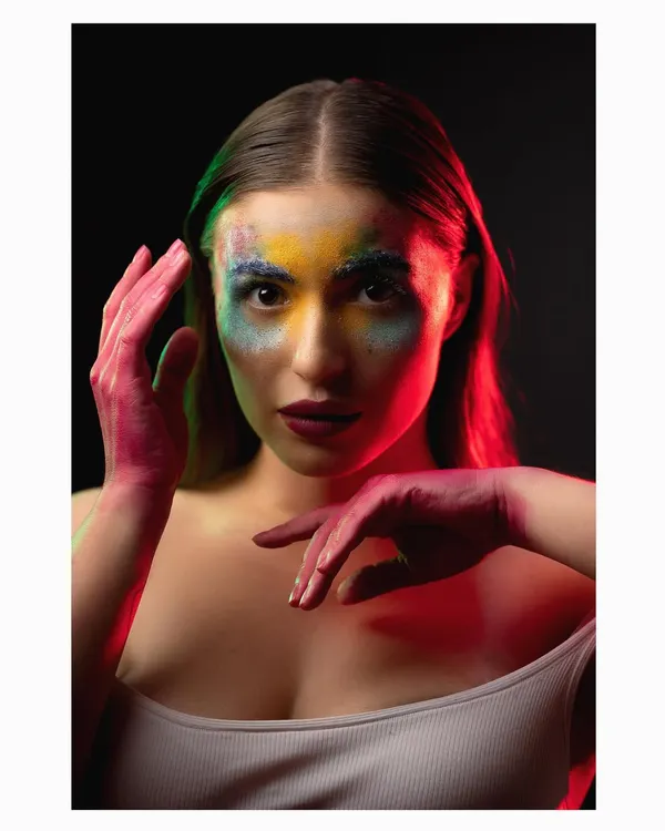 A creative beauty portrait using colorful powders and dramatic red and green lighting. This kind of experimental shoot is perfect for beauty editorials or artistic portfolios.