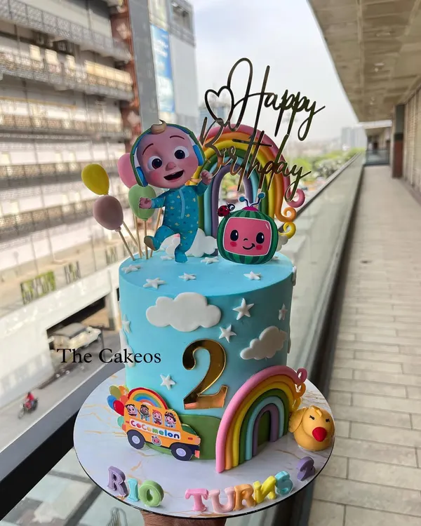 A vibrant Cocomelon themed cake perfect for a second birthday. This eggless cake features JJ, the iconic watermelon, a school bus, and colorful rainbows, bringing all the fun of the show to the party.