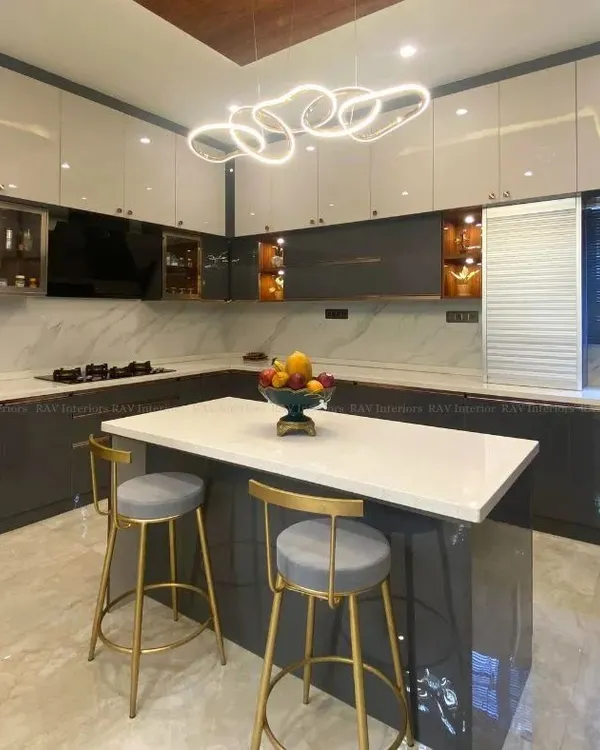 A stunning island kitchen featuring a white quartz countertop, perfect for meal prep and casual dining. The two-tone grey and white cabinets, combined with a modern light fixture, create a sophisticated and contemporary look.