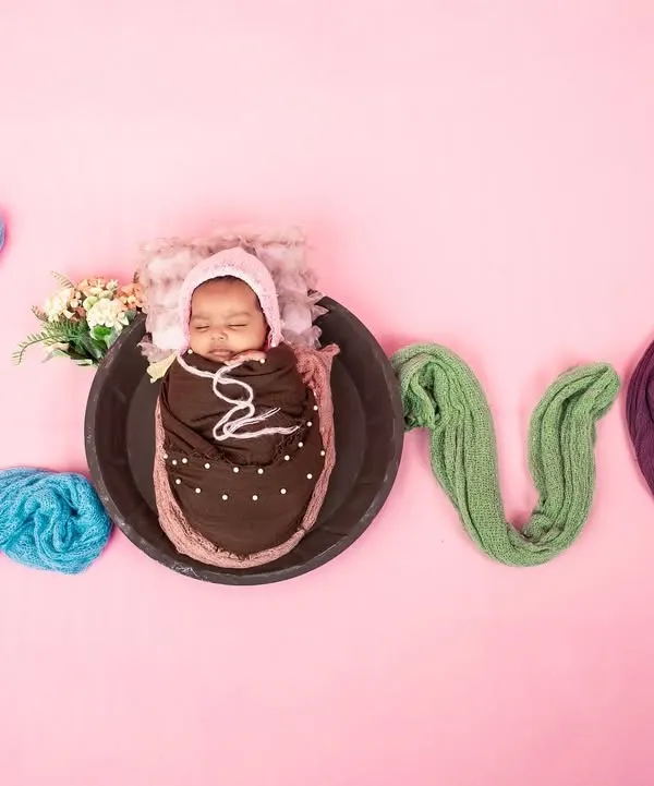 A creative and adorable newborn setup spelling out the word 'LOVE' with soft fabrics. This shot is a beautiful way to celebrate the new love in your family.