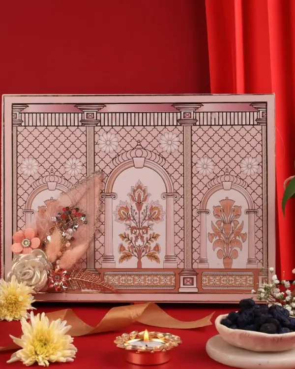A royal Diwali hamper styled against a rich red backdrop with traditional diyas and flowers to create a truly opulent feel.