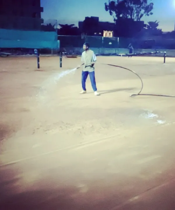 Our ground staff performing nightly watering of the clay courts, a crucial step in maintaining their quality for high-performance tennis.