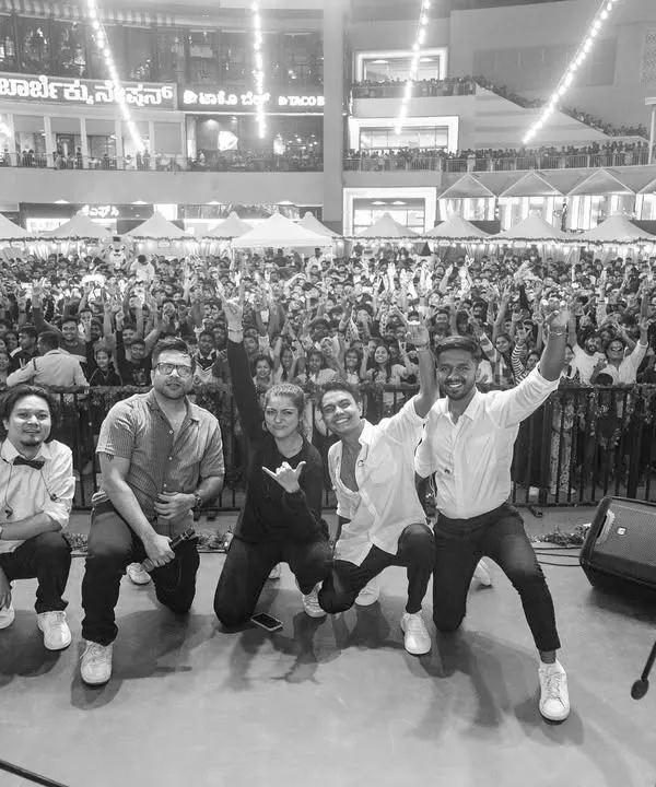 A black and white shot of us with a massive festival crowd. This image captures the scale of the events we play and the incredible connection we build with thousands of fans at once.