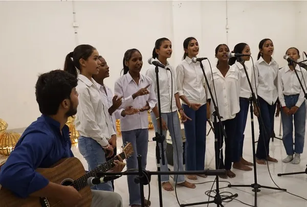 Our Gully Choir girls performing at the SEEkho Showcase. With their instructor on guitar, they sing in harmony, their voices filling the room with confidence and melody.