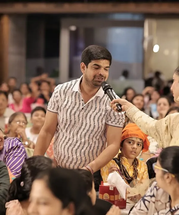 Handing the microphone to a guest in the audience. I believe in giving everyone a chance to share their wishes and stories, making the event more interactive.