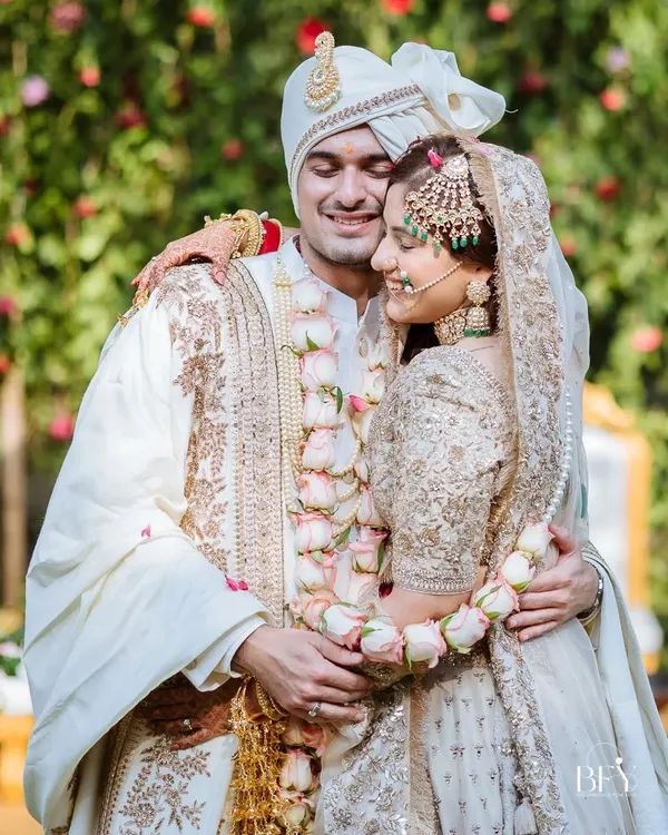 A beautiful, candid moment of the couple hugging after the varmala exchange, their faces filled with pure happiness.