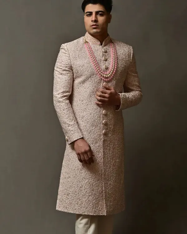 A full-length view of an elegant off-white sherwani with delicate embroidery. This pre-loved piece is perfect for a groom who wants a sophisticated and royal look.