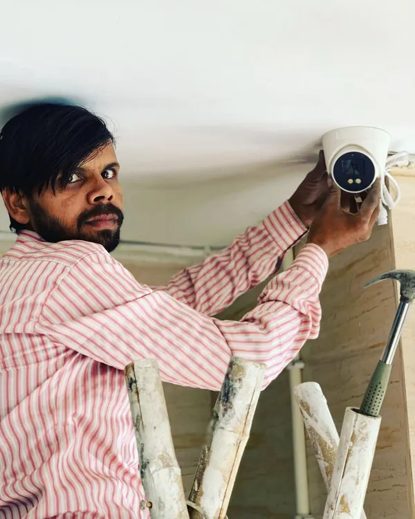 Our technician carefully installs a dome camera on a ceiling. We make sure the placement is perfect for wide coverage inside your shop or office.