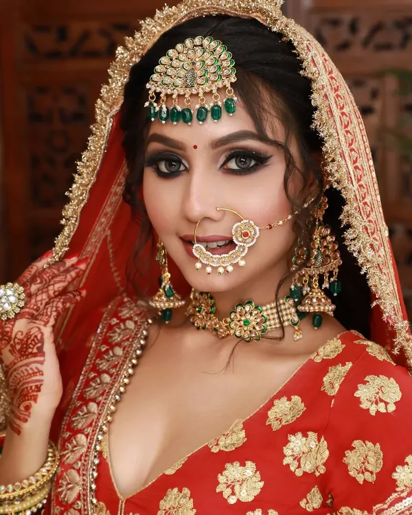 This is my signature high-glam bridal look. I focused on creating a flawless, radiant base with bold, defined eyes, perfectly complementing the traditional red lehenga and kundan jewelry. This look ensures you are absolutely breathtaking in person and on camera.