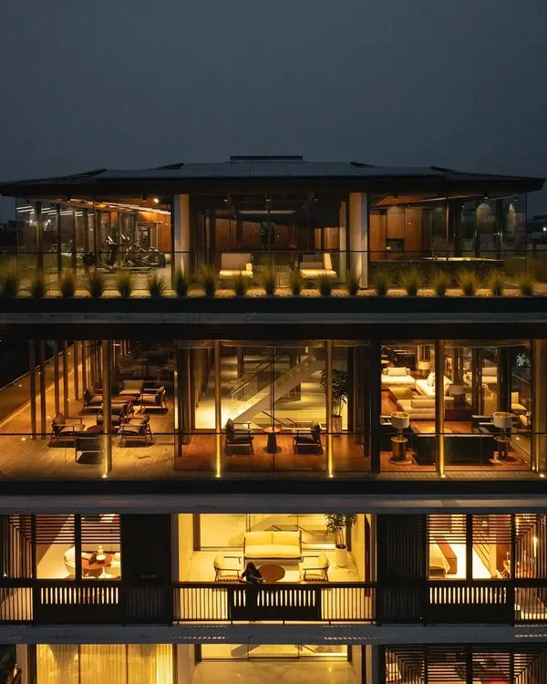 An evening view of the upper levels of 'The Light House', showcasing the glass-encased entertainment areas and rooftop deck that offer panoramic views of the Nagpur cityscape.
