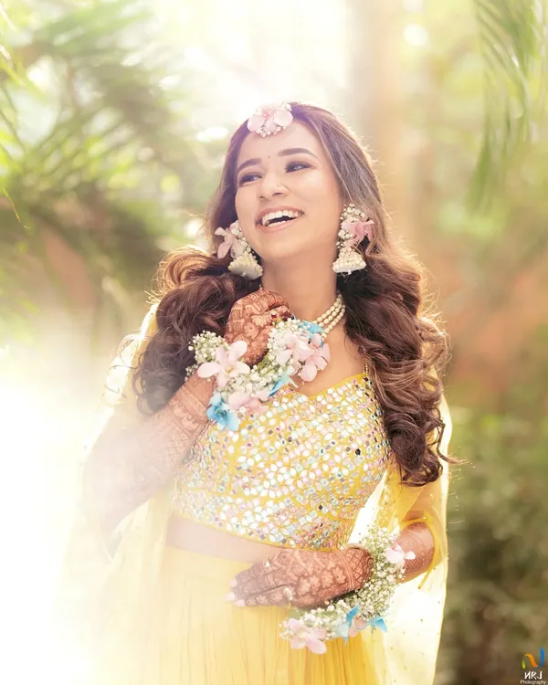 The pure joy of a Haldi ceremony, captured beautifully. We created this pastel floral set with a maang tikka, necklace, and haath phool to match her sunny yellow outfit.