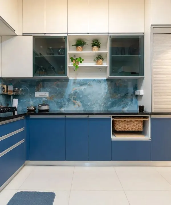 A stunning L-shaped kitchen featuring bold blue base cabinets and crisp white overheads. The design is elevated by a striking blue marble-patterned backsplash, creating a cohesive and dramatic look.