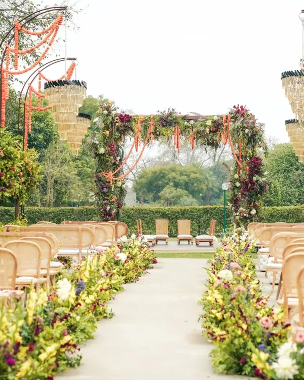 A walk down the aisle should feel like a dream. We lined this garden path with abundant blooms and hung elegant chandeliers from floral arches, creating a charming and luxurious entrance for the bride.