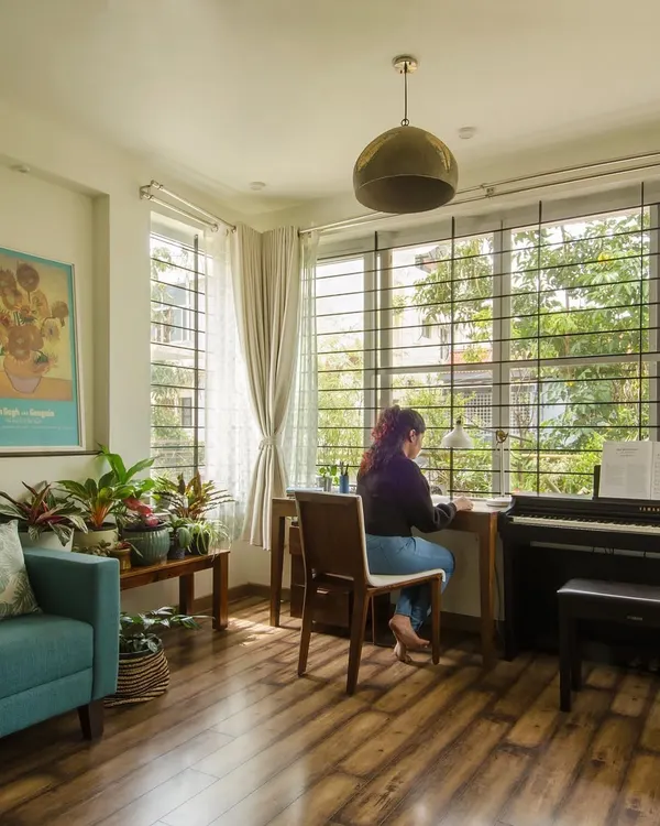 A home office addition designed to maximize its connection to the green outdoors. The large window allows natural light to flood the space, where the desk is positioned to offer a constant view of the garden.
