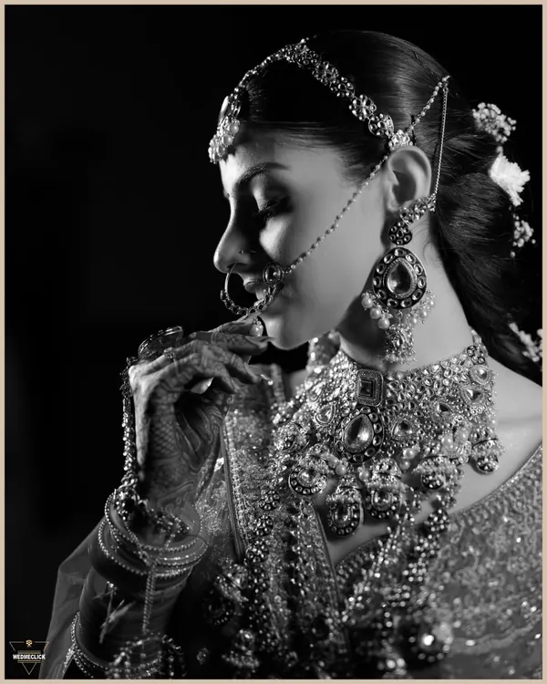 A timeless black and white portrait of the bride. This artistic shot highlights the intricate details of her jewelry and the classic beauty of her profile.