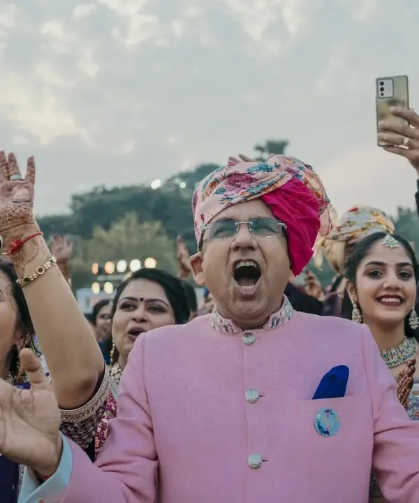 The groom's family cheering with all their heart during the varmala. Capturing the raw emotion and excitement of your family is so important.