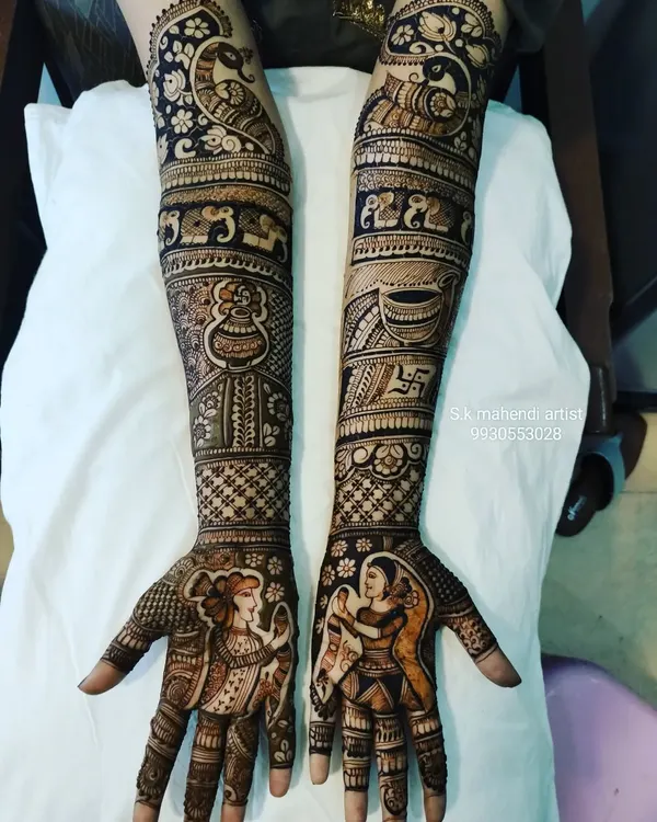 Getting ready for Navratri? I can create designs with festive figures like these Dandiya dancers. This full-arm mehendi also includes traditional elements like a kalash, swastika, and peacock.