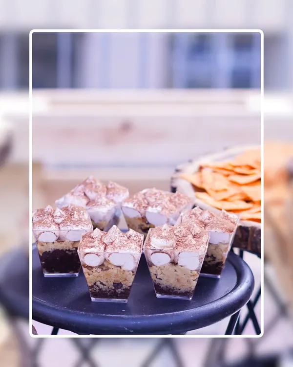 Our Tiramisu Shots are a decadent and elegant dessert option. Layers of coffee-soaked ladyfingers and creamy mascarpone are topped with cocoa powder and marshmallows, served in individual cups.