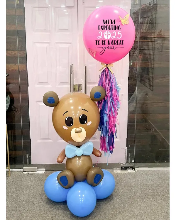 The most adorable way to share your big news! This teddy bear balloon sculpture, holding a personalized announcement balloon, is a sweet and memorable prop for a pregnancy reveal photoshoot.
