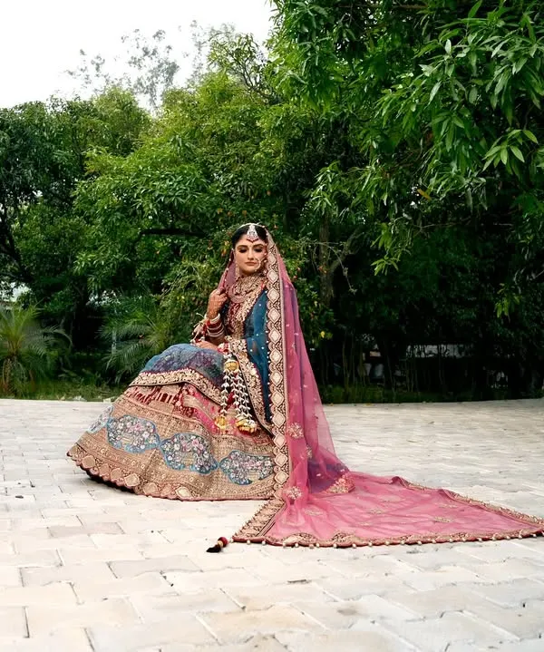 A breathtaking bridal portrait in Chamba, with the long pink veil of the lehenga spread out beautifully. I love using natural landscapes to create grand and elegant shots like this.