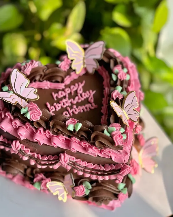 Edible art, but make it luxurious. This vintage heart-shaped cake combines rich chocolate and pink buttercream piping, delicate rosettes, and whimsical butterflies for a truly showstopping birthday centerpiece.