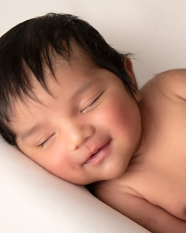 The purest smile, captured in a simple, clean portrait. My focus during newborn sessions is on your baby's natural beauty and peaceful expressions.