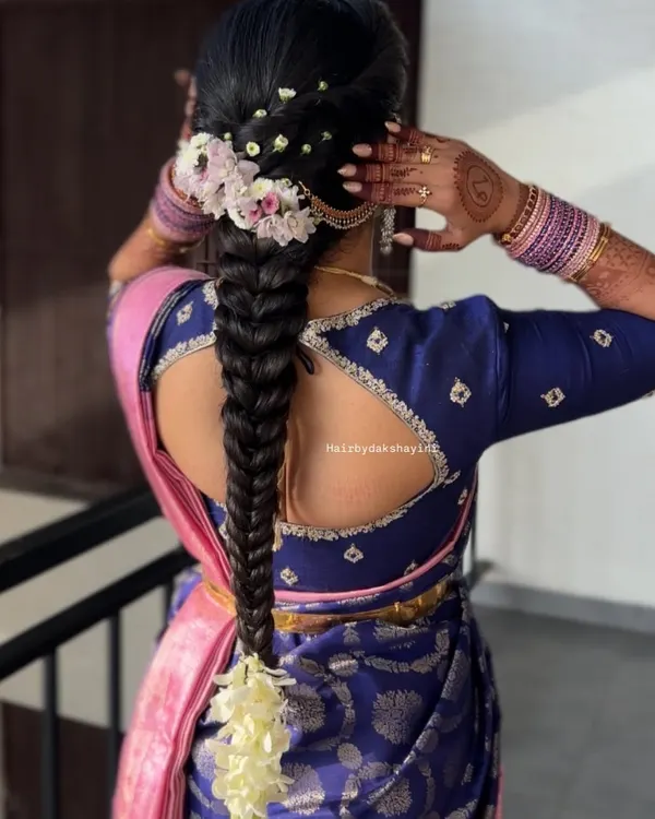 A beautiful fishtail braid adorned with fresh flowers. This hairstyle is a modern twist on the traditional braid and pairs wonderfully with silk sarees.