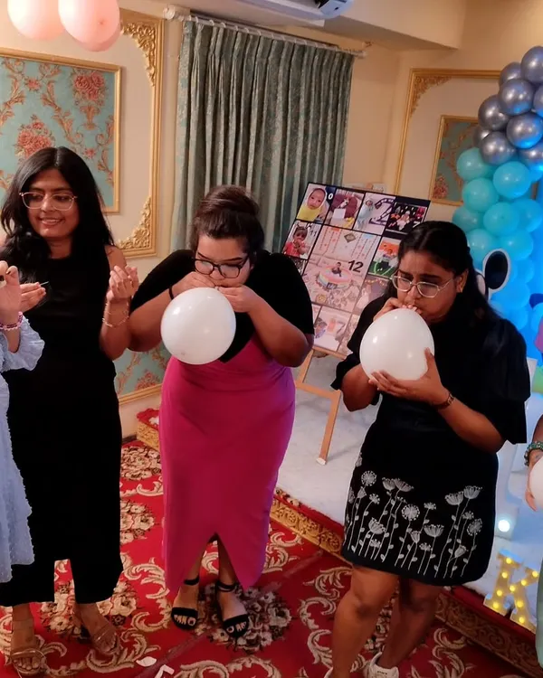 Guests participating in a fun balloon-blowing race at a birthday party. These simple but energetic games are perfect for getting everyone laughing and competing.