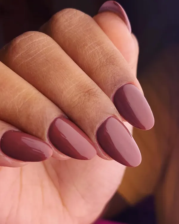 A perfect manicure for those who love classic elegance. These almond-shaped nails are coated in a rich, glossy dark chocolate brown polish for a look that is sophisticated, timeless, and versatile.