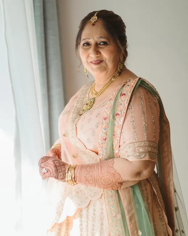 Timeless elegance for the mother of the groom. I created a soft, natural makeup look with a simple, neat hair updo to complement her beautiful pastel lehenga, focusing on a radiant and fresh complexion.