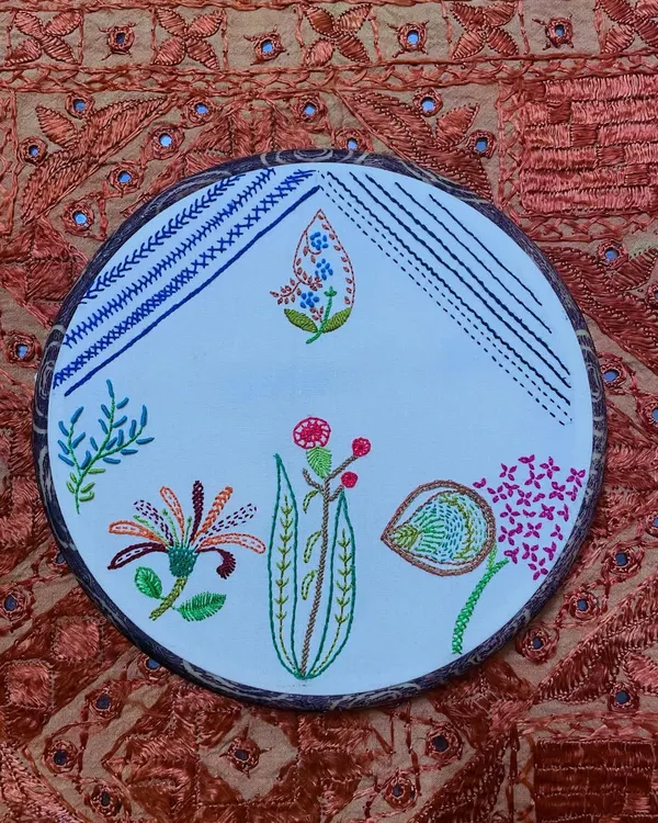 The satisfaction of finishing a project is immense. This hoop art piece, with its mix of stitches and floral motifs, is truly captivating and ready to hang on a wall.