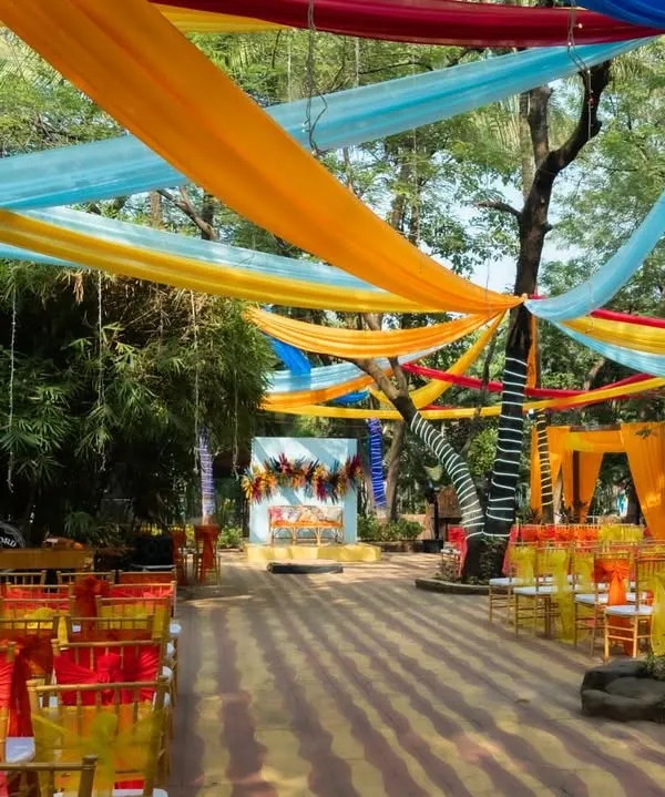 An overview of our carnival-themed decor for an outdoor event, featuring a canopy of bright, colorful drapes and vibrant seating arrangements.
