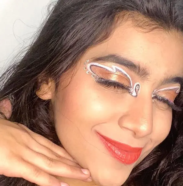 A simple but stunning graphic eyeliner look using white liner to create abstract shapes above the crease. It's a great way to add an artistic touch to your makeup.