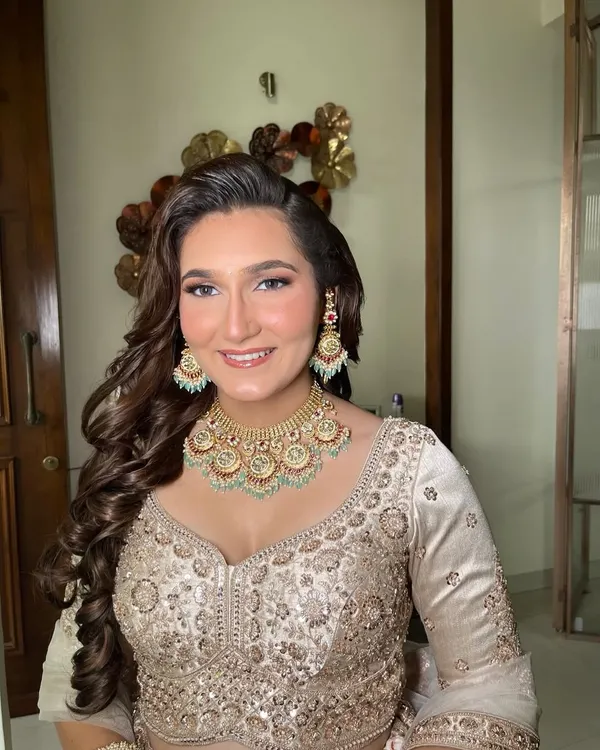 Unfiltered glam for an engagement or sangeet. This look features a dewy base, soft smokey eyes, and voluminous curls, perfect for a night of celebration.