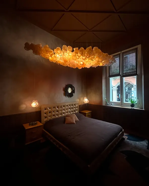 This is how I transform a room into a sanctuary. The Bocci 100 series floats like a luminous cloud above this serene bedroom, creating an atmosphere of pure tranquility. Each hand-blown glass piece is part of a larger, custom composition designed to evoke emotion and artistry.