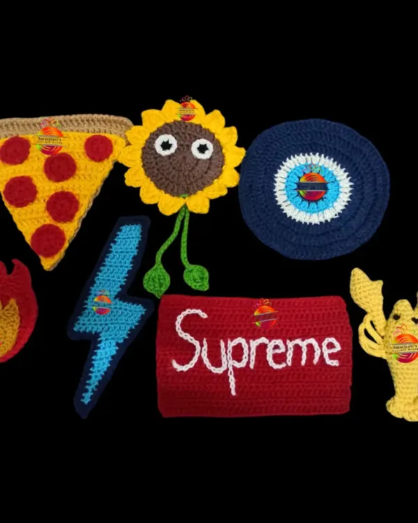 A collection of my custom-made crochet patches, also known as appliques. You can see a pizza slice, a sunflower, an evil eye, a lightning bolt, and even a lobster, ready to be sewn onto any item.