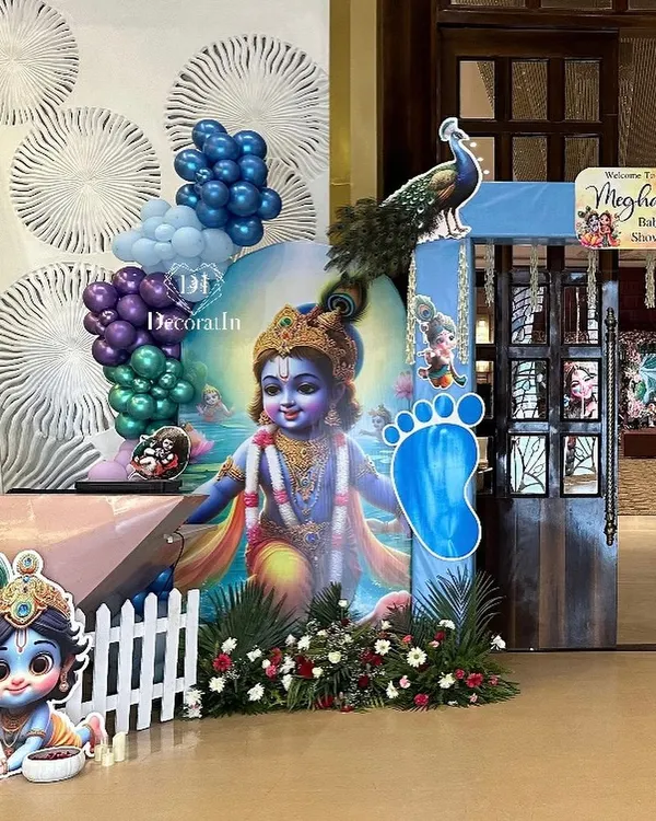 A divine welcome for a little one with our Krishna-themed baby shower decor. This grand entrance features a large cutout of baby Krishna, peacock details, and a vibrant balloon garland, creating a blessed and beautiful atmosphere.