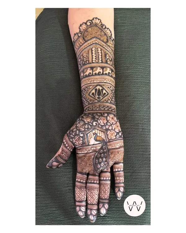 A beautiful and intricate design for the mother of the bride, featuring elephants, lotuses, and a peacock.