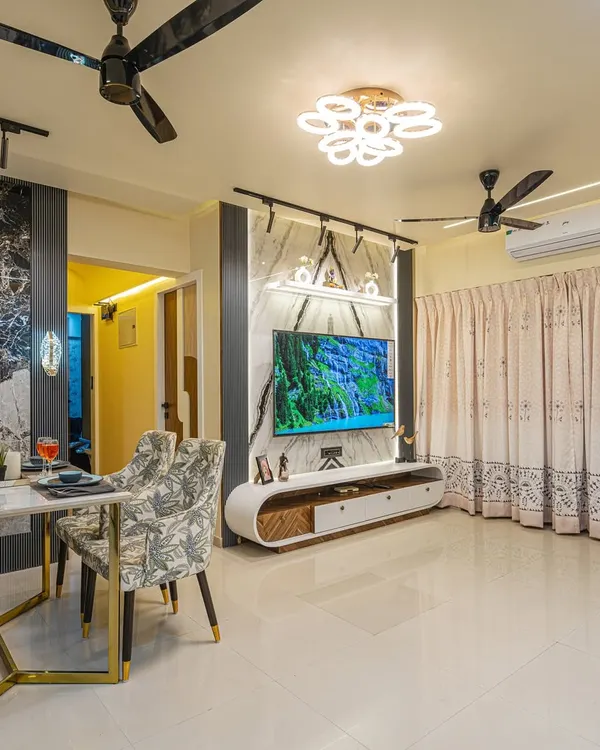 This view shows how the living and dining areas are connected. I used consistent design elements like the marble-finish wall panels and gold accents to create a unified, high-end look throughout the open-plan space.